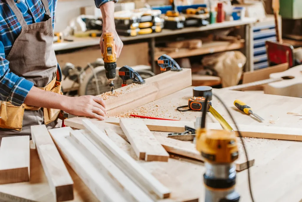 Joiner drilling a timber plank in the workshop